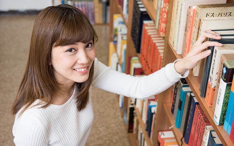 図書館で本を手に取る女性